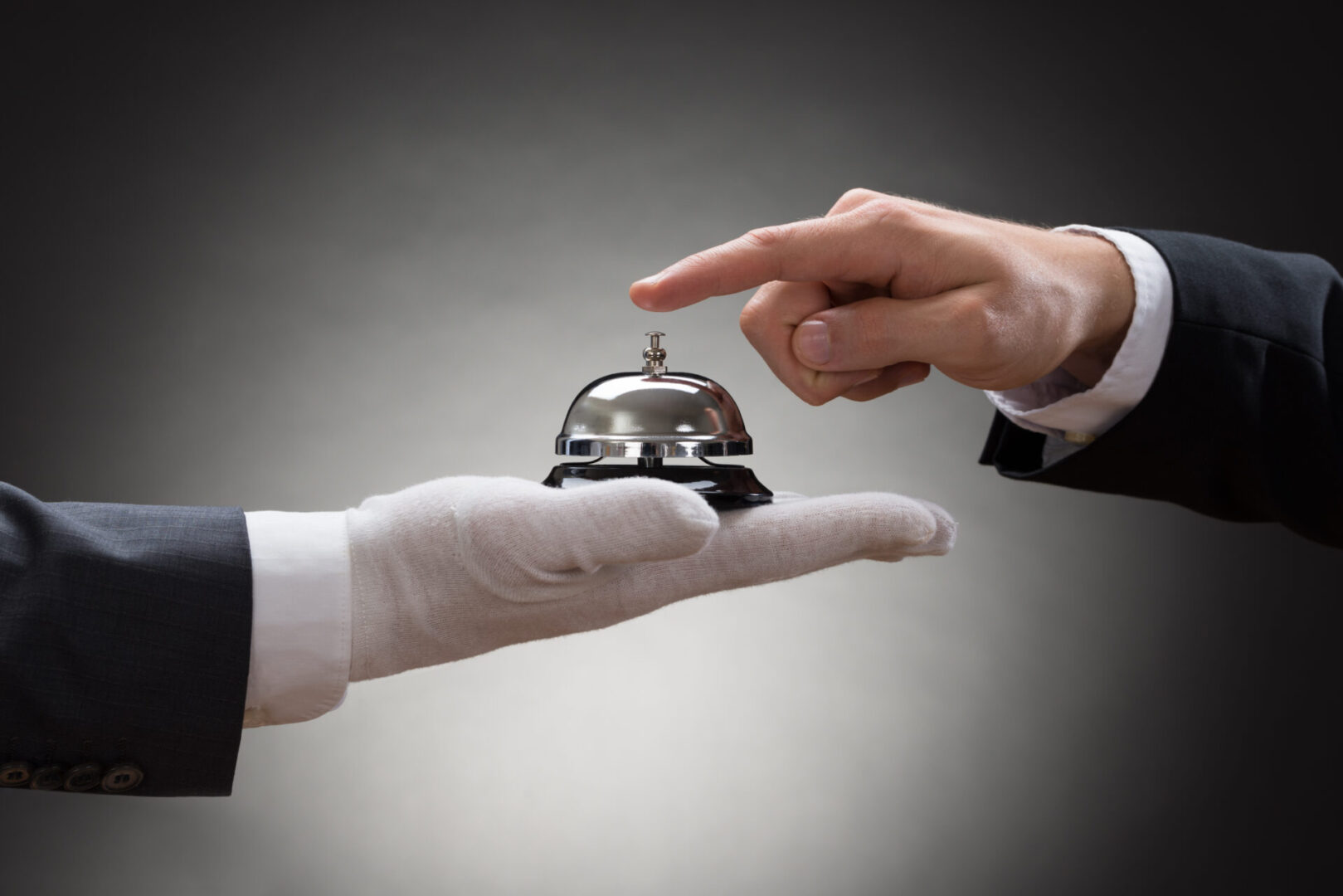 Close-up Of A Person's Hand Ringing Service Bell Hold By Waiter